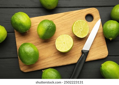 Green lime with cut in half on cutting board on black background. Top view - Powered by Shutterstock