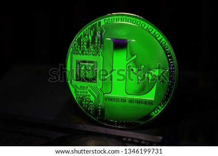 Green Litecoin LTC coin is surrounded by a gloomy background.