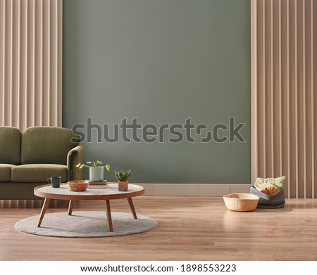 Green living room wall background with grey decorative chair, lamp frame middle table and poster style.