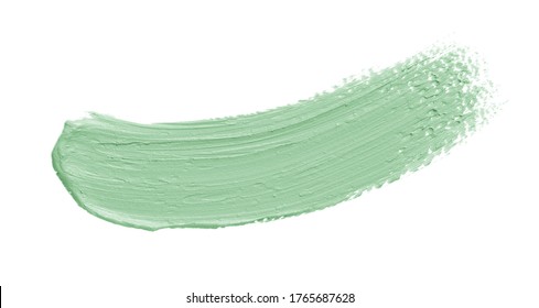 Green makeup cream swatch isolated on white background. Color correcting concealer smear smudge brushstroke. Makeup creamy texture