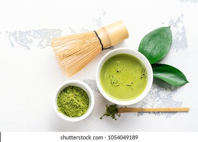 Green matcha tea drink and tea accessories on white background. Japanese tea ceremony concept. Copy space