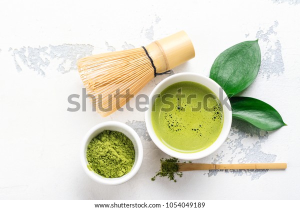 Green matcha tea drink\
and tea accessories on white background. Japanese tea ceremony\
concept. Copy space