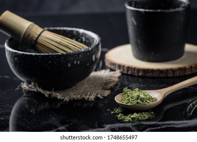 Green Matcha Tea Powder With Spoon On Black Marble Background.