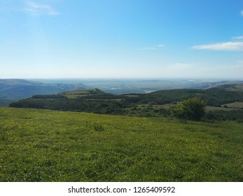 green meadow in the mountains, blue sky, clouds