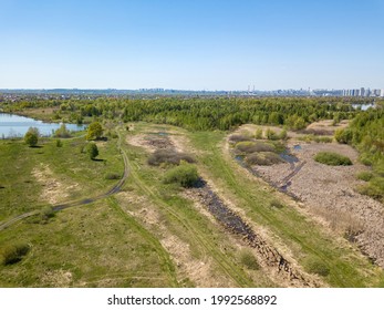 Green meadows on the outskirts of the city in spring. Aerial drone view. - Shutterstock ID 1992568892