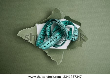 Green measuring tape on a light background. Tool for measuring length and volume. Tape for measuring in the clothing industry or the volume of the human body