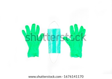 Green medical protective surgical rubber gloves and mask on white background.