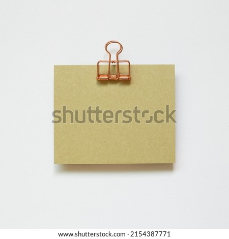 Green memo pad and metal clip isolated on white background. top view, copy space