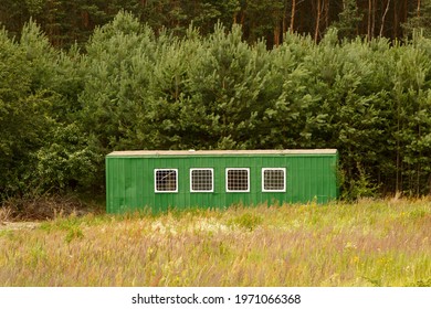 Green metal shed for builders. A shack for farmers in the forest. - Shutterstock ID 1971066368