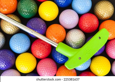 Green mini golf putter with balls of assorted colors