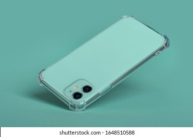 Green Mint IPhone 11 In Clear Silicone Case Falls Down, Back View. Phone Case Mockup Isolated On Green Background