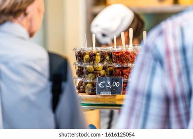 Green Mixed Olives On Display In Florence Italy Central Market In Plastic Container With Sign Price And People Buying