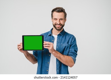 Green mockup screen for ad copyspace freespace. Caucasian young man holding digital tablet, showing screen with mobile application, online social media isolated in white - Powered by Shutterstock