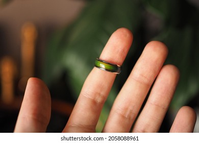 Green Mood Ring Detail On The Index Finger Of An Open Hand