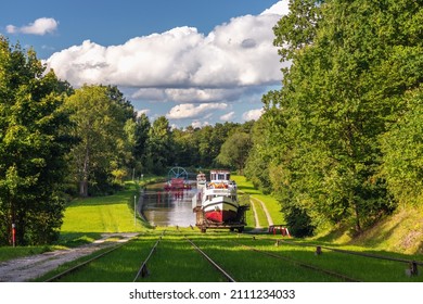 Green nature of the Elbląg Canal (Kanał Elbląski), famous landmark of Warmian-Masurian, Poland. Boat hauled on the link cradle up the inclined plane to overcome the difference in water levels. - Shutterstock ID 2111234033