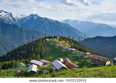 Green nature, snowy mountains and traditional wooden plateau houses (yayla evi) of northeastern Karadeniz region of Turkey. Landscape shot was taken in June 2019 at Sal - Pokut Plateau, Rize.