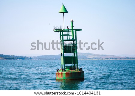 Green navigation buoy with cone topmark floats on sea water. Bay of Burgas, Black Sea, Bulgaria
