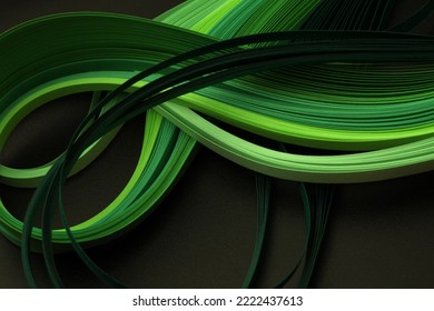 Green neon color strip wave paper on black. Abstract texture copy space background.