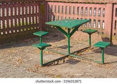 Green Old Metal Table With Green Chairs Surrounded By A Wall