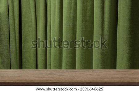 green olive sackcloth curtains at background with oak wooden table at foreground. image monatge for product displayed in minimal mood and tone. empty wood table with green draped.