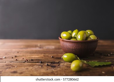 Green olives, bay leaf on a wooden board. - Powered by Shutterstock