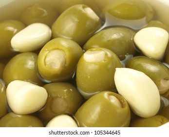 Green olives in oil with garlic cloves, closeup - Powered by Shutterstock