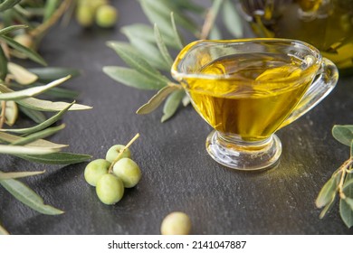 green olives with olive oil on a dark background - Shutterstock ID 2141047887