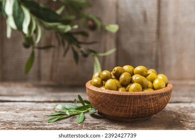 Green olives on a white wooden background. Various types of olives in bowls and olive oil with fresh olive leaves. Copy space. Place for text. Mediterranean food. Vegan. - Powered by Shutterstock