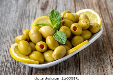 Green olives stuffed with peppers. Natural peppered olives on wood floor background. Healthy food. close up - Powered by Shutterstock