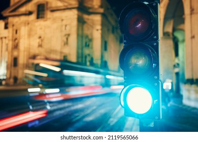 Green on traffic light against tram and cars in blurred motion. Night scene of city street in Prague, Czech Republic.
