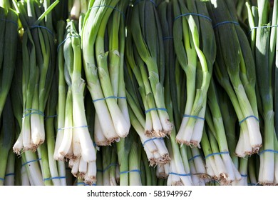 Green onions, fresh bundles lay on the counter of a village market