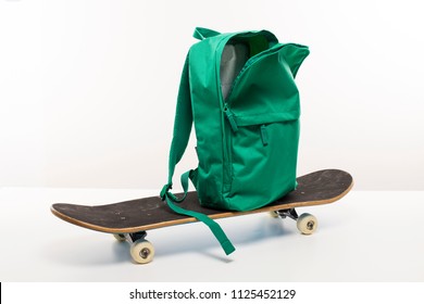 Green Open Backpack Sitting On Skateboard, Back To School Concept