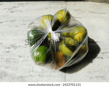 Green orange fruits in a poly bag 