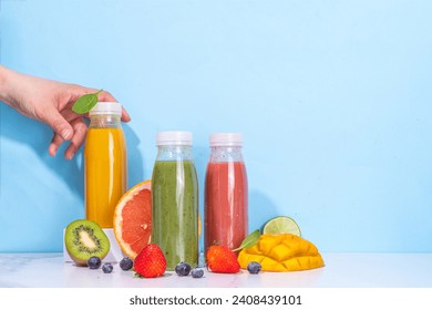  Green, orange and red smoothie in portion bottles, Mix of colourful healthy smoothie or juice drinks of different  fruits: orange, grapefruit, lime, kiwi, strawberry, with ingredients - Powered by Shutterstock