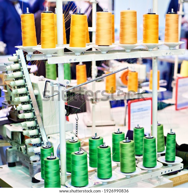 Green\
and orange spools of thread in a sewing\
workshop