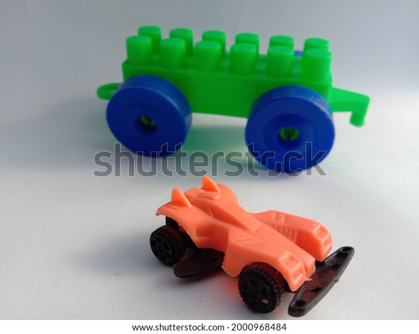 green and orange\
toy car with white\
background