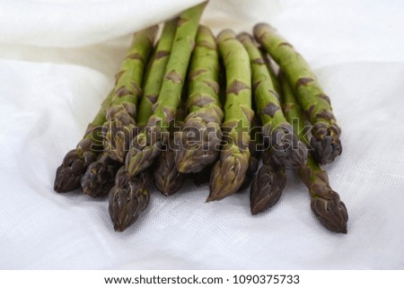 Green organic asparagus on white cloth. Closeup