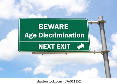 Green overhead road sign with a Beware Age Discrimination Next Exit concept against a partly cloudy sky background.