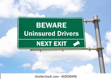 Green overhead road sign with a Beware of Uninsured Drivers Next Exit concept against a partly cloudy sky background. - Shutterstock ID 403030498