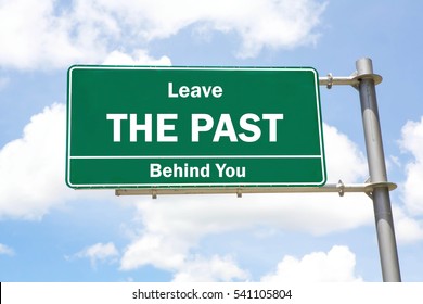 Green Overhead Road Sign With A Leave The Past Behind You Concept Against A Partly Cloudy Sky Background.