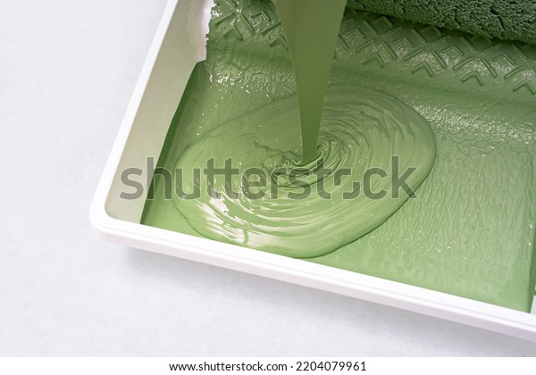 Green Paint being poured into paint tray                \
              