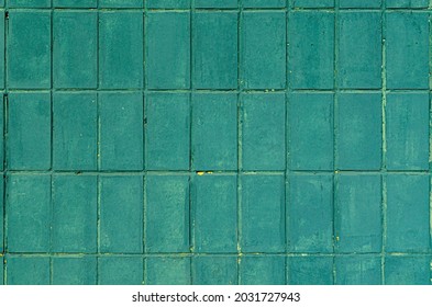 Green Paint Square Tiles Texture. The Wall Is Casually Lined With Rectangular Small Tiles.