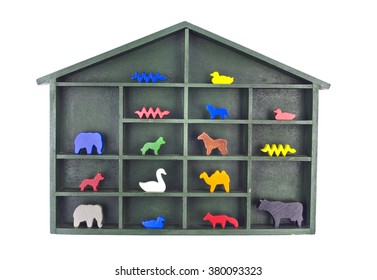 Green painted wooden shelf with a roof filled with various wooden animal toy figurines isolated on white
