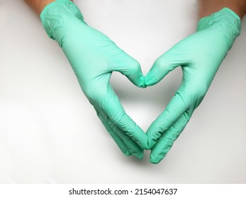 A Green Pair Of Nitrile Medical Gloves On Hand. Women's Hands On A Light Table