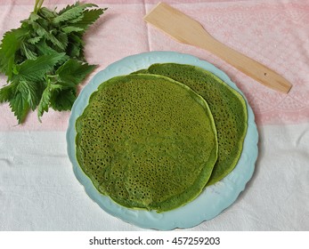 Green pancakes with nettle on plate, organic food