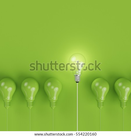 Green pantone light bulbs with glowing one different idea on pastel green background. minimal concept. top view.