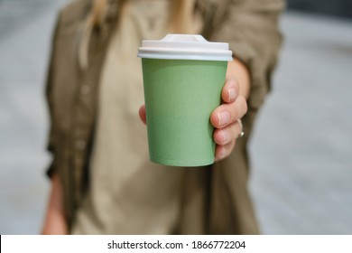 Green Paper Cup With Coffee In Woman Hand. Time For Drink Coffee In City. Coffee To Go. Enjoy Moment, Take A Break. Disposable Paper Cup Closeup. Delicious Hot Beverage. Blank Space For Text, Mockup