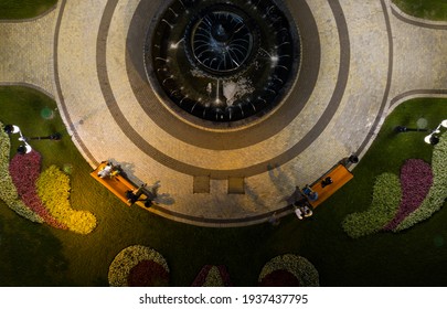 Green Park With Round Fountain, People On The Benches. View From Above.