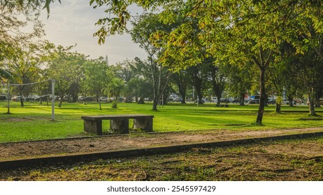 A green park with a stone bench providing a serene escape from the hustle and bustle. - Powered by Shutterstock