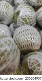 green pears taste sweet, still wrapped in plastic sold in supermarkets - Shutterstock ID 2302049579
